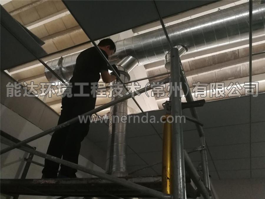能達環(huán)境設(shè)計生產(chǎn)的型號為DAHT-7000熔噴布廢氣處理設(shè)備的排氣筒正在從房頂穿出進行安裝調(diào)試作業(yè)1
